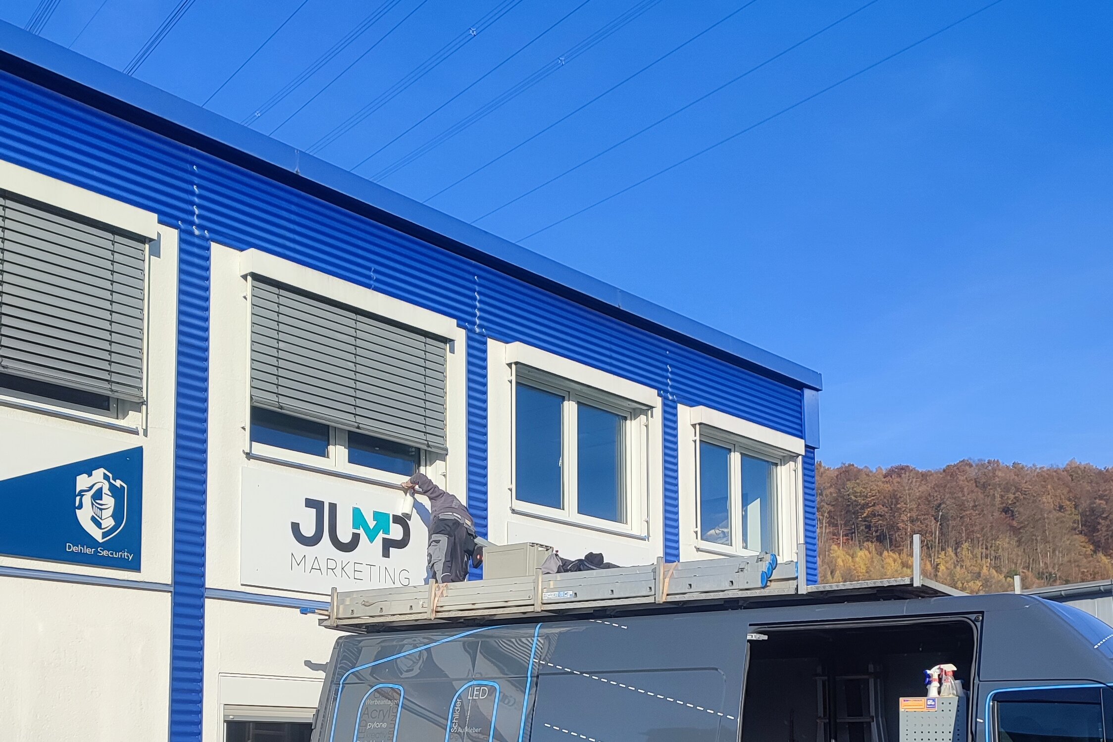 Montage des JUMP Marketing Logoschildes durch Utsch Werbetechnik